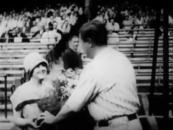 B/W 1927 Babe Ruth bringing sister Mamie bouquet of flowers in ballpark / newsreel Stock Footage