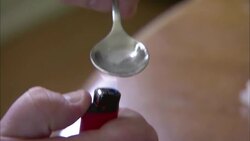 The flame from a lighter cooks heroin in a spoon. Stock Footage