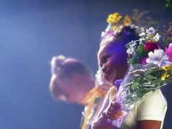 Medium shot young ballerina accepting flowers and smiling / ballerinas in background holding bouquets + looking at CAM Stock Footage