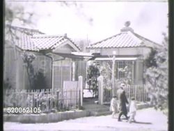 1942: JAPAN: FAMILY: WS Few Japanese people walking outside house. INT VS Family (w/ elderly couple) drinking tea at table. MS Female pouring tea for male. BRIEF MS Elderly female smoking pipe. Grandparents Instructional Video