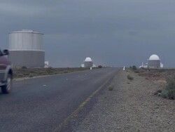 WS PAN Car driving towards observatories as lightning flashes / Western Cape, South Africa Stock Footage