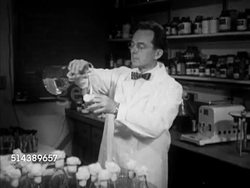 1953: YALE UNIVERSITY SCIENCE:  VS Scientist & Yale University Science professor Paul Rufus Burkholder working in laboratory, pouring liquid into flask, examining samples in tubes. Lab, antibiotics Instructional Video