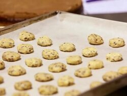 CU Shot of pastry chef putting chocolate chip cookie dough in baking pan / Rome, Lazio, Italy Stock Footage