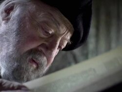 An old man reads a page near a map. Stock Footage