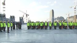 An officer walks in front of a platoon wearing reflective vests and standing at attention. Stock Footage