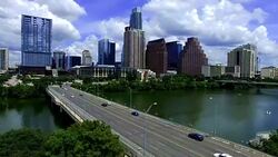 Aerial: Over Town Lake with Congress Avenue Bridge spanning Colorado River with Downtown Skyline across the horizon Stock Footage