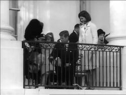 B/W 1963 slight zoom out John + Jacqueline Kennedy with children sitting on balcony / newsreel Stock Footage