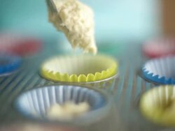 CU Shot of woman spooning cupcake mixture into cup cake cases / Auckland, New Zealand Stock Footage