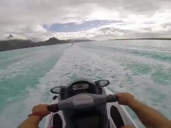 POV of man riding a personal water craft in the lagoon around Bora Bora island in French Polynesia. - Slow Motion Stock Footage