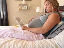 A young women using a technological device while pregnant. Stock Footage