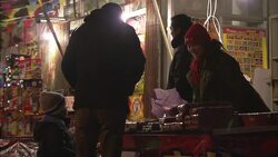 A father and his young son stand next to a fireworks stand in Beijing. Stock Footage