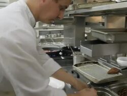 POV LA chef in restaurant kitchen placing potatoes on plates in preparation for plating Stock Footage