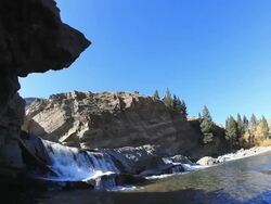 Water flowing over rocks creating a small waterfalls Stock Footage