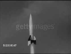 1953: FILMING ROCKET FLIGHT: VS Man attaching camera into V-2 rocket, LAUNCHING: WS V-2 rocket taking off, ascending. MS Hand w/ chalk drawing on blackboard, 20 miles up, 60 miles, flipping past peak of trajectory, line back down. Note: Film lines, sp Instructional Video