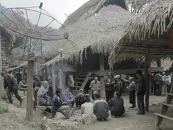 WS people sitting outside huts / Xam Neua, Laos Stock Footage