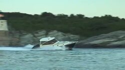 A man rides a powerboat past Newport's Castle Hill Lighthouse. Stock Footage