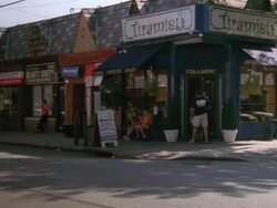 MS PAN view of  Tiramisu cafe and down small town city street with shops/restaurants on bottom of two story office buildings / Flushing,New York, United States Stock Footage