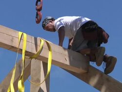 WS ZO Carpenter removing strap rafter beam from crane while framing an energy efficient post / Grass Lake, Michigan, USA    Stock Footage