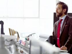 MS smiling businessman standing in discussion at table in office workstation Stock Footage