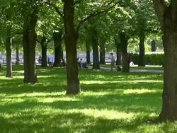 WS Shot of people seating and walking through hofgarten garden showing green grass field / Munich, Bavaria, Germany Stock Footage