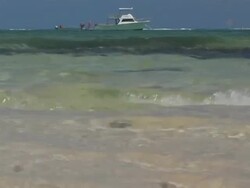 CU, Cayman Islands, Grand Cayman, Smiths Cove, Waves on beach, yacht in distance Stock Footage