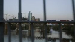 View from Pfluger Pedestrian Bridge as freight train cars cross railroad bridge over Colorado River in Austin, Texas at sunset Stock Footage