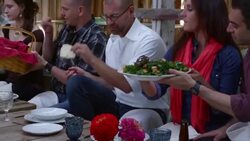 MS PAN Family and friends dishing up food on plates during dinner party in rustic building Stock Footage