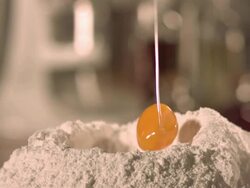 egg yoke falling into pile of flour in kitchen. Stock Footage