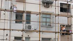 Workers paint the wall of an old residential building Stock Footage