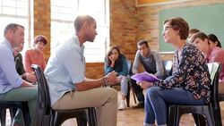 Woman taking notes in group therapy session Stock Footage
