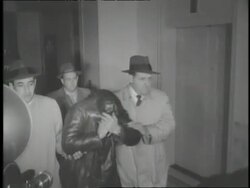 A suspect in the Boston Brinks Robbery hides his face as photographers try to take his picture. News Clip