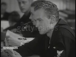 1935: US NAVY: Enlisted men sitting in room reading, talking. Bridge of ship. CU Alarm bell. Navy sailors, officers, leaving room, running in ship's halls, sailors manning machines, officer using sighting scope for artillery. Instructional Video