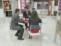 TS WS  kitchen salesman and young couple seated at desk discussing plans Stock Footage