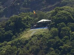 MS AERIAL TS  Shot of paraglider by mountain range / Rio de Janeiro, Brazil Stock Footage