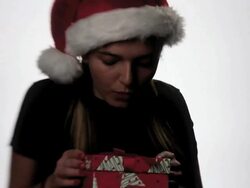 Girl in Santa hat opens a present. Stock Footage