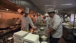 Flames flash in a busy restaurant kitchen as chefs call for ingredients from the sous chefs. Stock Footage