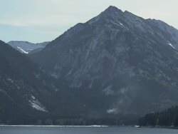 WS View of Lake Wallowa glistens on sunny winter day with snowy mountains rising steeply, From Oregon's "Little Switzerland" / Joseph, Oregon, United States  Stock Footage
