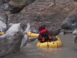 'Medium Long Shot hand-held-Kayakers paddle around ice chunks in a river. / Alaska, USA' Stock Footage
