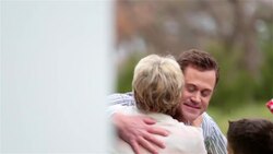 Grandmother welcomes and hugs son-in-law, stoops to talk with grandchildren Stock Footage