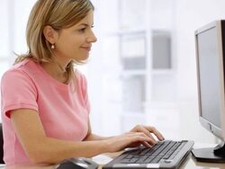 Young woman working at computer in office. Stock Footage
