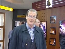 Sir Roger Moore shortly after heart problem diagnosis flies out of Heathrow Stock Footage