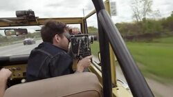 Young man shoots driving footage with vintage film camera in classic Bronco Stock Footage