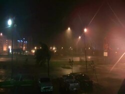 Signs and trees being blown in rain by hurricane force winds, street lights go out, Hurricane Wilma, USA Stock Footage