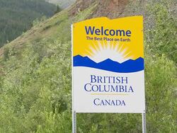 CU Shot of Road sign for British Columbia The Best Place on Earth, on Haines Highway and forest mountains behind, Yukon and British Columbia border / Yukon/British Columbia, Canada Stock Footage