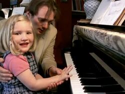 Slow motion medium shot man giving daughter piano lesson / girl smiling at CAM Stock Footage