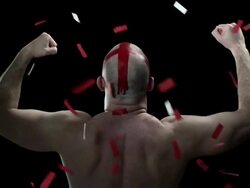 Man with red cross painted on his head with ticker tape flexing muscles Stock Footage