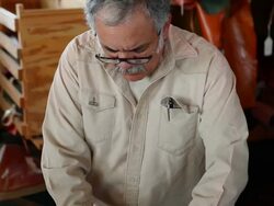 TD R/F MS boot maker trimming excess leather from sole of cowboy boot Stock Footage