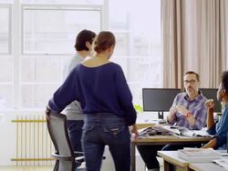 MS businesswoman pulling up a chair to  sit down to join informal project meeting in office Stock Footage