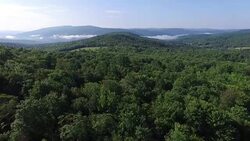 4K aerial footage rising above the trees in the Catskills, in upstate New York. 3840 X 2160. Sunny day. Stock Footage