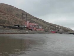 The old coal-fired power plant at the harbor of the Russian settlement and coal mining community Pyramiden on the archipelago of Svalbard, Norway Stock Footage